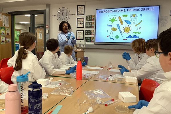Teacher with students showing a presentation about microbes and their relationship to humans - friends or foes